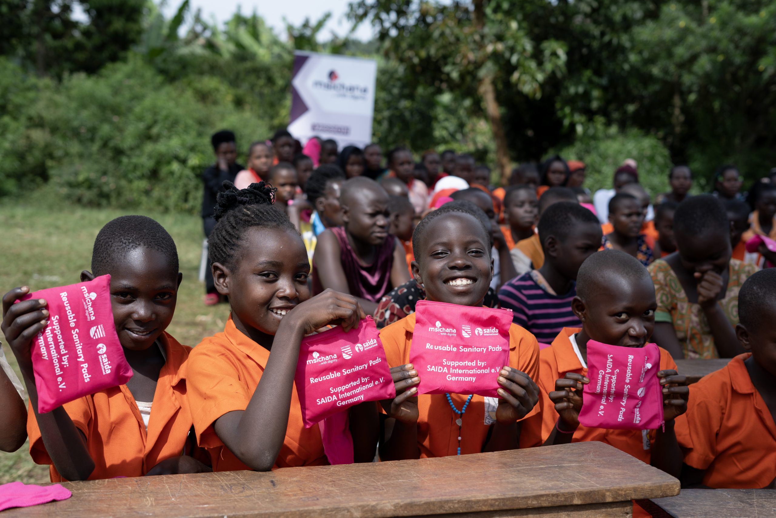 Girls from Nsanja UMEA P/S holding reusable sanitary pads from Msichana Uganda