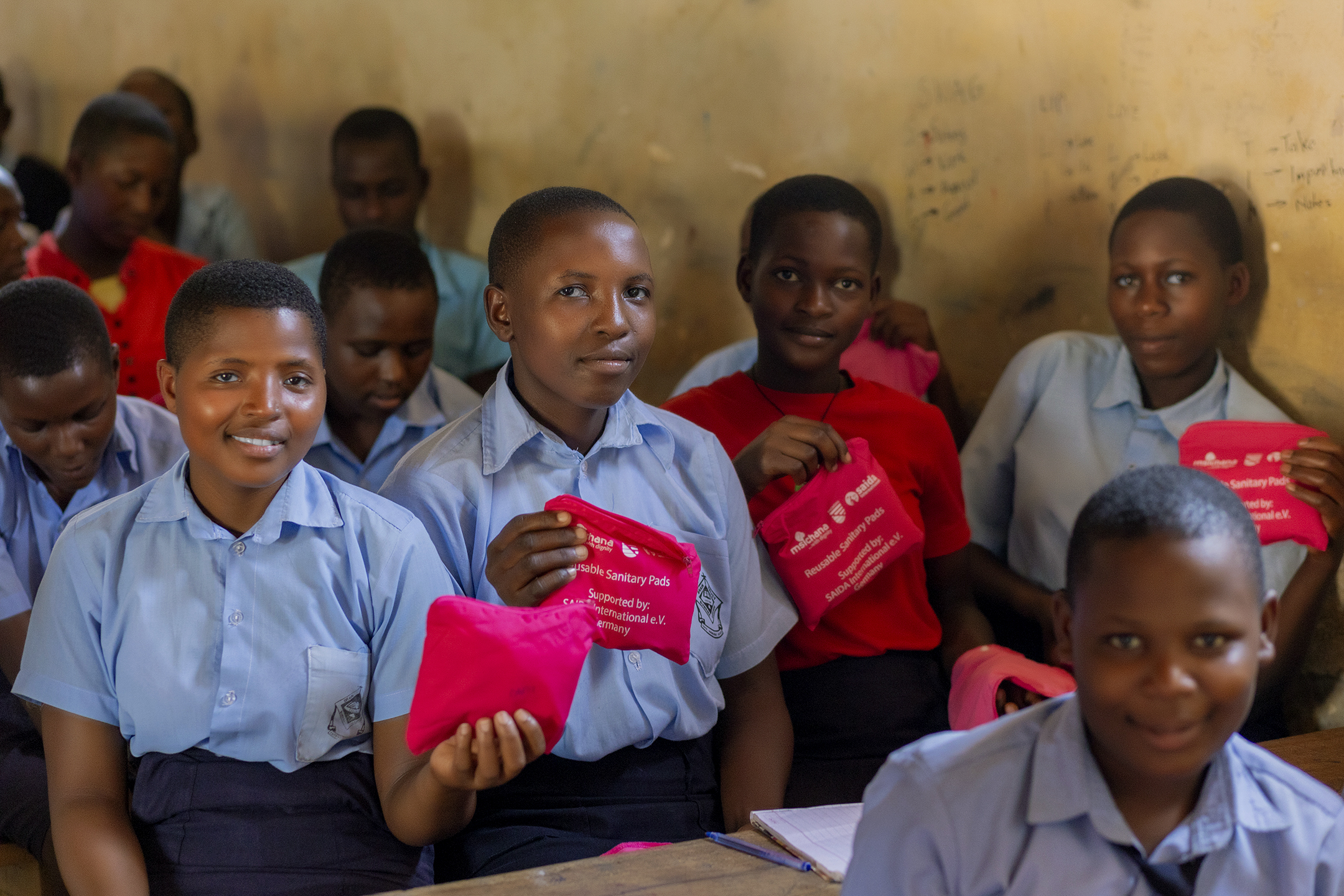 Girls holding reusable sanitary packs from Msichana